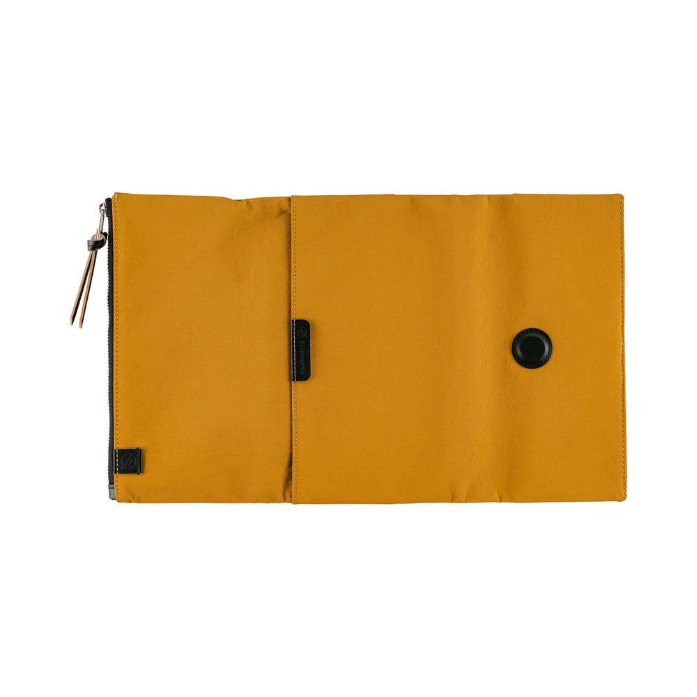 Its standout feature is the generously sized pocket, but its overall appearance remains clean and minimal. The vibrant yet subdued mustard color gives it a beautiful finish that suits anyone, regardless of style. Though it folds into thirds and fastens with a magnetic closure, the cover is light in hand. The aim was effortless elegance, something that looks sharp without being flashy. The material is a soft nylon with a sophisticated sheen.
