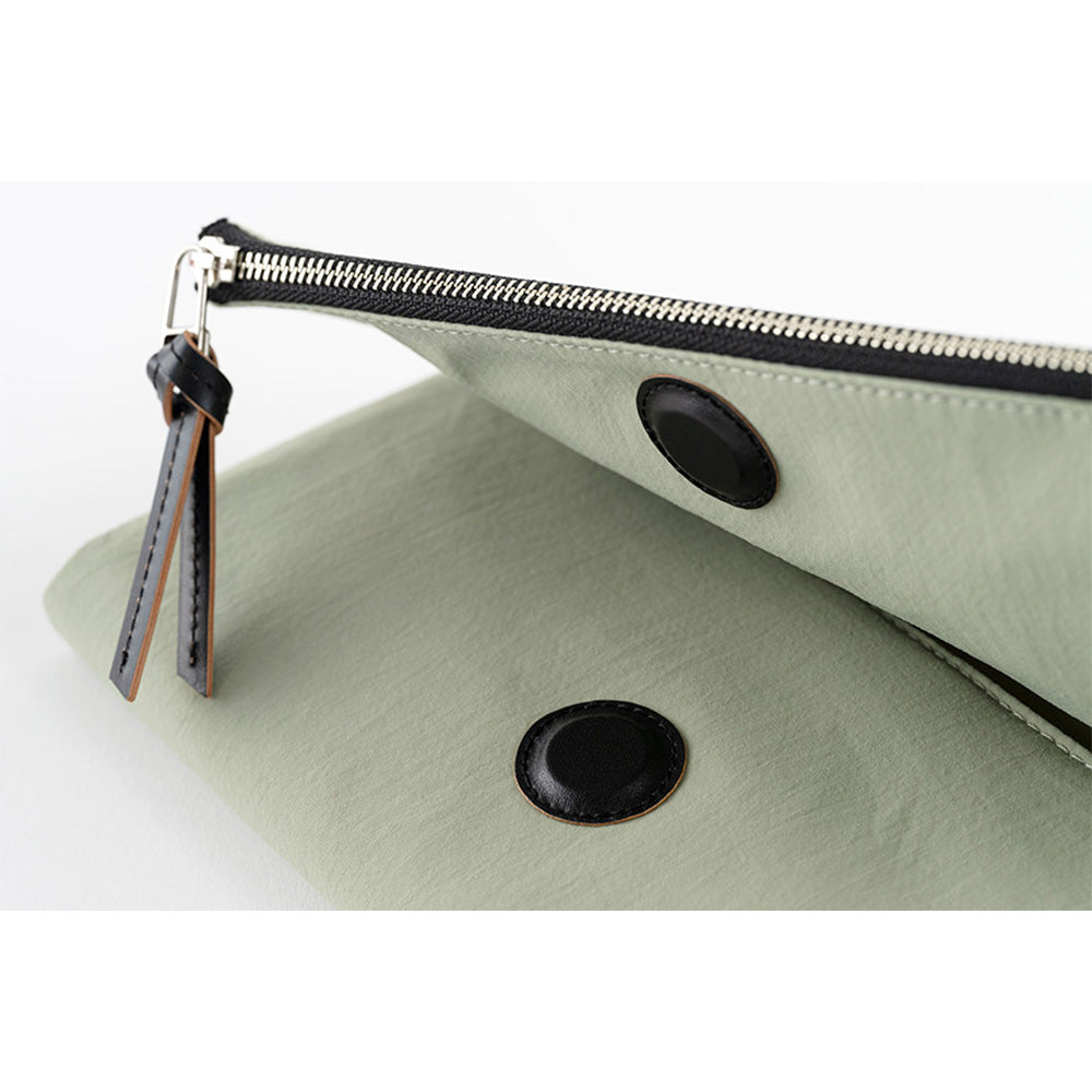The cover closes with a hidden magnet, which is padded with a leather patch for a softer touch. The outer pocket also features a leather zipper pull.