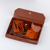 Hobonichi Alettone: Document Case for A6 Size Brown leather case with orange cable and alcohol pad on a white background