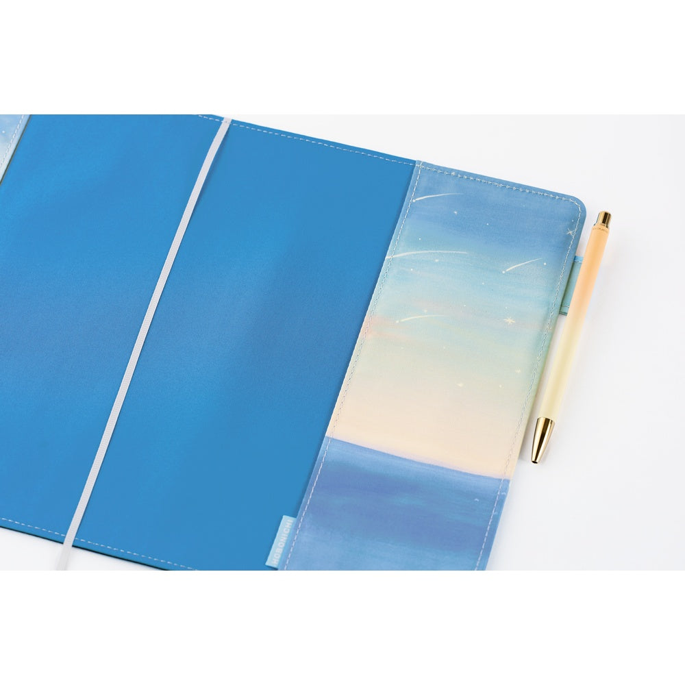 The sky and sea expand into the interior of the cover. The bookmark is in a pale gray with a muted shine, blending into the quiet scenery. The pen hook on the inside lets you store your pen by its clip, while still maintaining the cover’s clean, refined silhouette when closed.