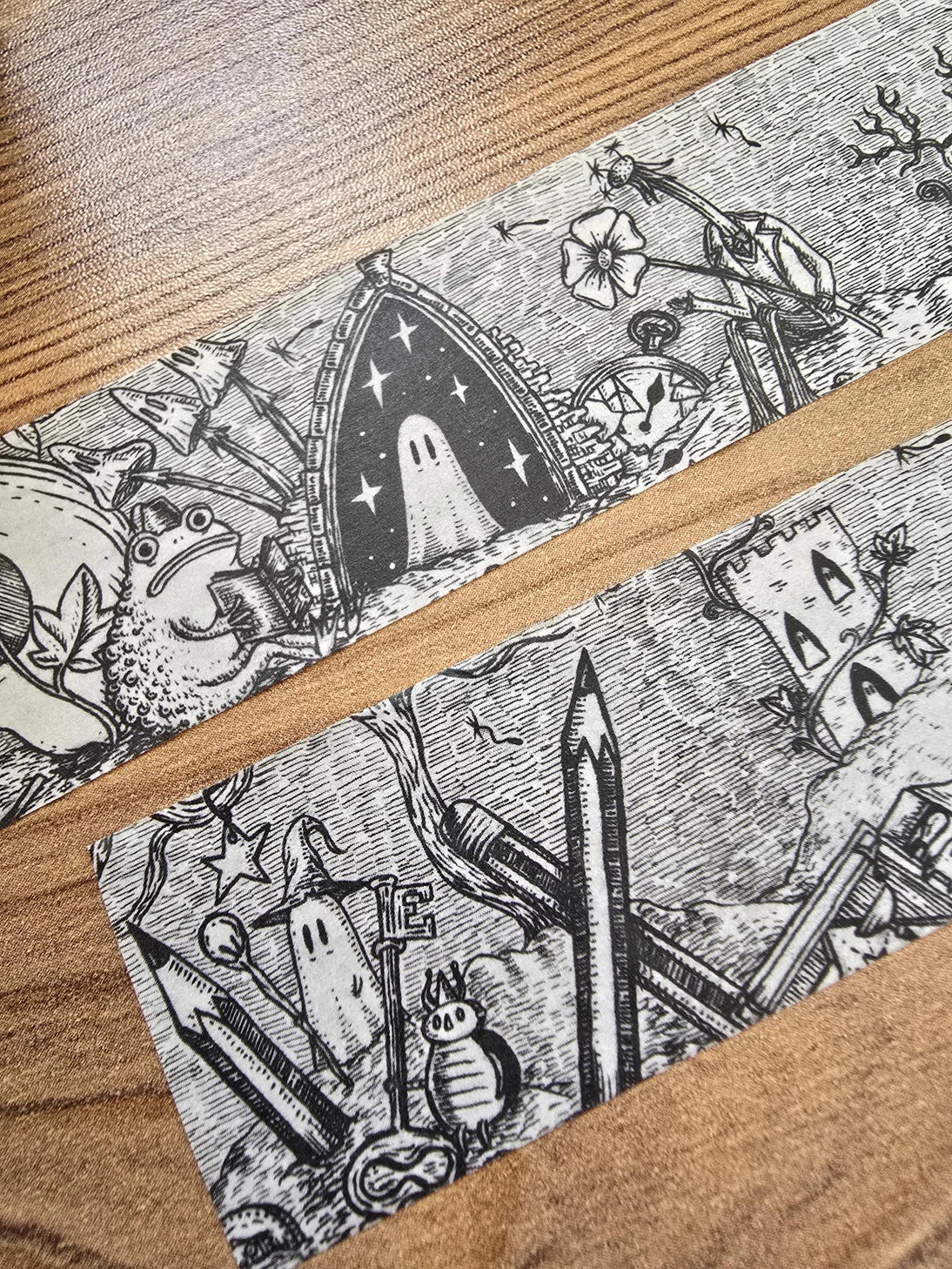 A unique and infinitely repeating fantasy landscape of melancholy oddities and curious characters, from original hand-drawn ink artwork by Jon Turner, recreated with incredible detail at miniature size in this washi tape that invites you to find new tiny details with every viewing.

This is a special extra-wide washi tape, 30mm high which really brings out all the tiny details. perfect for creating a decorative border when journalling, or for packing parcels with surreal style. 10m long.