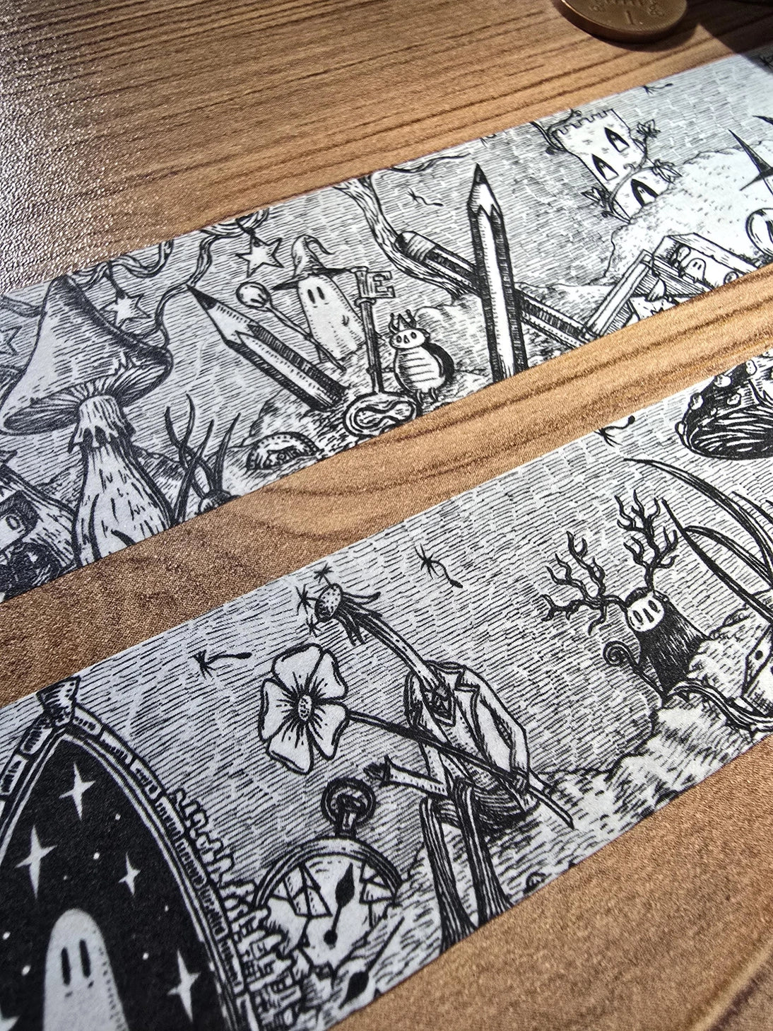 A unique and infinitely repeating fantasy landscape of melancholy oddities and curious characters, from original hand-drawn ink artwork by Jon Turner, recreated with incredible detail at miniature size in this washi tape that invites you to find new tiny details with every viewing.

This is a special extra-wide washi tape, 30mm high which really brings out all the tiny details. perfect for creating a decorative border when journalling, or for packing parcels with surreal style. 10m long.