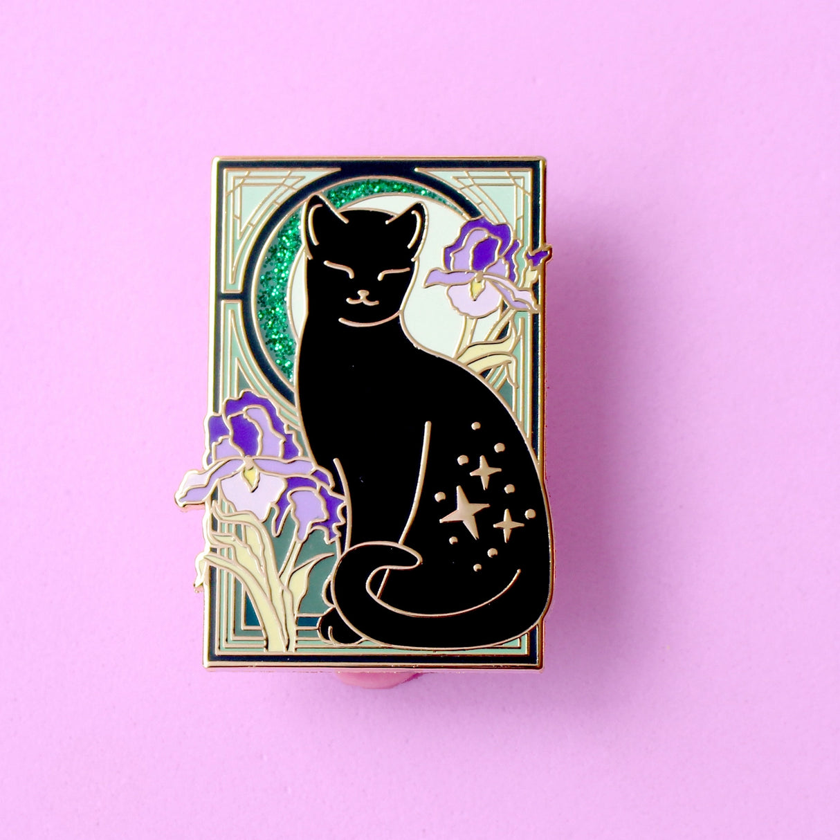 This cute Iris Cat enamel pin features a sweet black cat surrounded by iris (flag) flowers, in front of a glittery moon set against an ornamental green art nouveau background.

The pin is secured by two purple heart backs and comes on a special ‘Art Nouveau’ Glitter Punk backing card, making it perfect for a gift or to keep as a special treat for yourself.

This pin is part of my Art Nouveau Cats collection – 8 enamel pins based on the fabulous 19th/20th century art movement. Check out the full collection a
