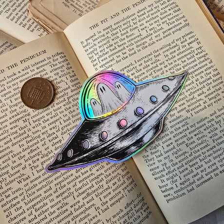 A spooky little UFO on a lovely die-cut holographic vinyl sticker from original pen and ink artwork by Jon Turner.