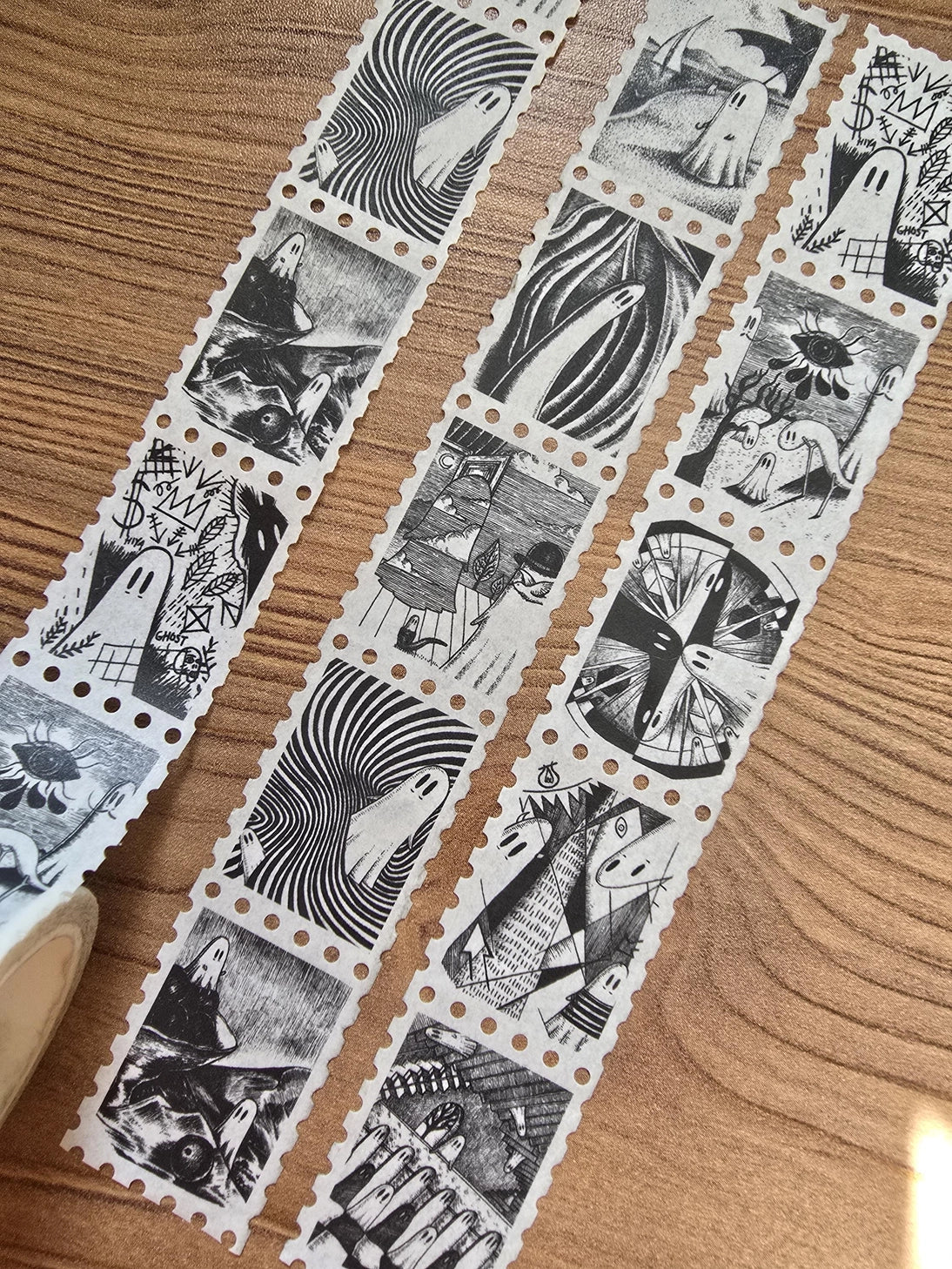 The second of two tapes from the Creative Spirits series by Jon Turner, little ghosties taking you on an eclectic tour of art history. This roll features ghosts inspired by Bridget Riley, Rene Magritte, Hilma Af Klimt, Georgia O'Keeffe, Salvador Dali, Paul Cezanne, Pablo Picasso, Georges Seurat, MC Escher, and Jean-Michel Basquiat.

Perforated to look like a roll of postage stamps, this washi tape features a repeating pattern of ten designs in portrait format from hand-drawn pen and ink artwork, recreated i