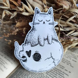 Sticker featuring a spooky little cat sitting contentedly on a skull, from my original pen and ink artwork.

Die-cut vinyl sticker, suitable for interior or exterior use. Measures approximately 7.5cm (3 inches) high, and 5cm (2 inches) wide.&nbsp;
