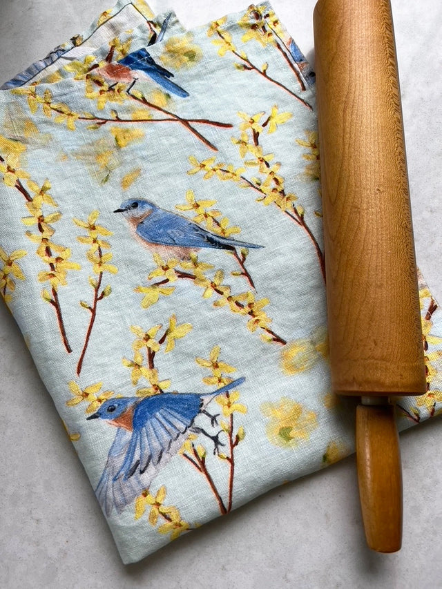 Introducing this bright spring colored pattern of blue birds and yellow forsythia that will add a touch of elegance and serenity to your home. Bringing a sweet whisper of the outdoors into your kitchen.

Crafted from 100% premium linen, this towel measures 17.5 x 26 inches, blending beauty with utility. Each comes with a belly band, perfect for gifting and a corner hang loop for hanging.

Designed by Kasey. Imported.

Artwork copyright Kasey Melissa Art 2025.