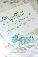 Kitty Inkpot Apricot Blossoms of Early Spring Ink 杏花酿春色 - A gentle teal‑mint ink that captures the fleeting beauty of spring’s first bloom. Blossoms of Early Spring flows like morning dew across paper, soft, translucent, and full of quiet life. Its shading dances between misty jade and pale turquoise, evoking apricot petals kissed by sunlight.