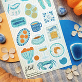 🩴🍊 @papergrapeprints is serving up a sun-soaked spread of seaside favorites, and we’ll take one of everything! Bright oranges, sardines, pasta, pretty ceramics, hydrangeas, and that perfect blue crab come together in a dreamy mix of coastal color and vacation-day charm. Add flip-flops, something cold to sip, and absolutely zero plans. Art by: @papergrapeprints

Top Coating: None
Adhesive Layer: Paper
Backing Layer: Clear PET
6.69" x 3.54".
Weight - 0.03lbs
1 sheet included
