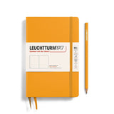 A hardcover Leuchtturm1917 Rising Sun notebook in orange color with a matching orange pencil, both featuring the brand's logo.