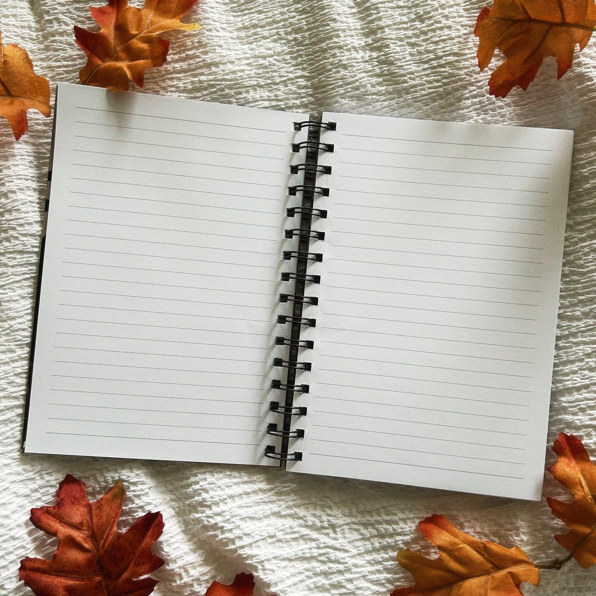 A new A5 notebook featuring ghosties strolling through the cemetery!

This hardcover notebook comes lined and with an elastic band. There are 96 double sided pages.