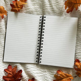 A new A5 notebook featuring ghosties strolling through the cemetery!

This hardcover notebook comes lined and with an elastic band. There are 96 double sided pages.