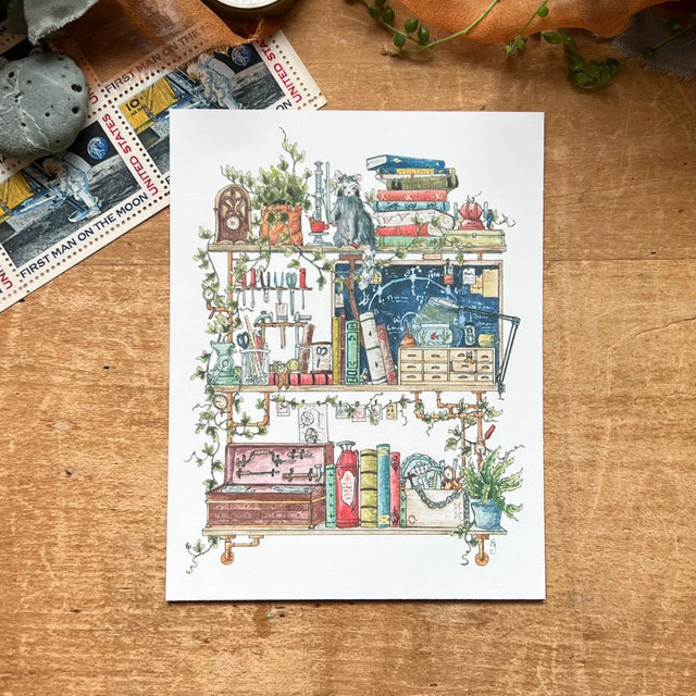 Postcard featuring my original watercolor and ink illustration of the oddities, books, and tools tucked away in the shelves of a vintage inventor, including an assortment of tiny robots, a fire extinguisher, and a raccoon who is definitely not certified to operate the drill press.
