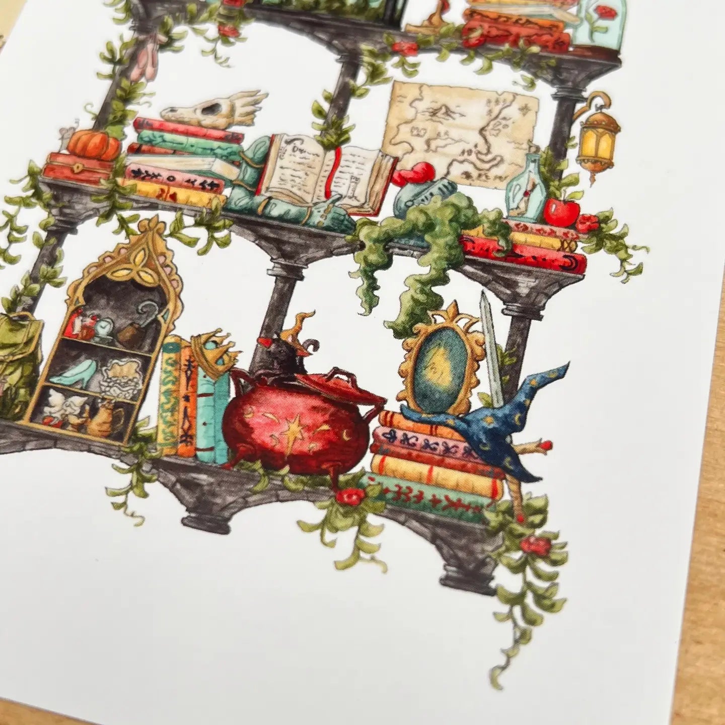Postcard featuring my original watercolor and ink illustration of the various enchanted items collected by a storybook witch as she travels throughout all your favorite fairytales, including a charming castle, a glass-encased rose, and a brightly colored dragon, all nestled on stone shelves that evoke mysterious castle corridors covered in rose vines.