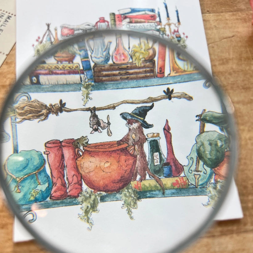 Postcard featuring my original watercolor and ink illustration of the oddities, books, tools, and trinkets tucked away in the shelves of a swamp witch, including an assortment of creatures brewing up a potion, and an alligator skull holding a crystal ball.