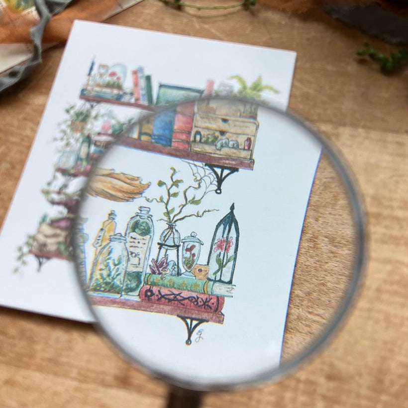 Postcard featuring my original watercolor and ink illustration of the oddities, books, tools, and trinkets tucked away in the shelves of a witch, including a sunglasses-wearing spirit in a skull, a crystal ball that knows exactly what groceries you need this week, and a black cat.

• Printed on high quality card stock
• Each postcard measures 4.25 x 5.5" (A2)