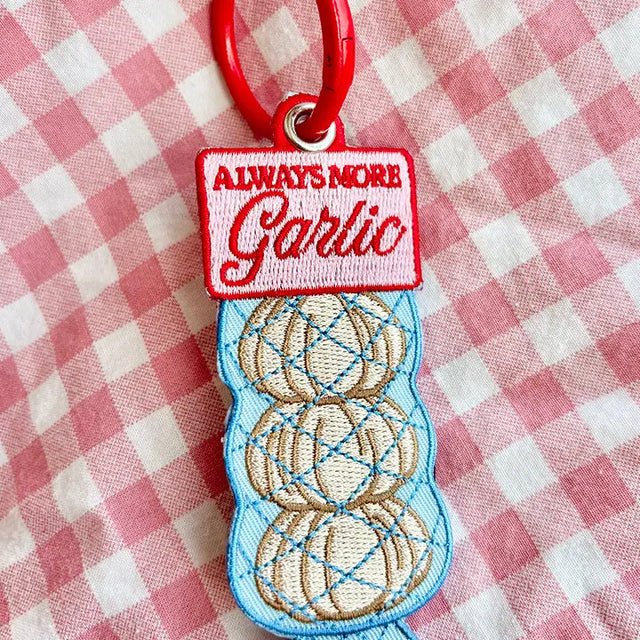 These cute embroidered keychains attach with a colorful ring clasp and are perfect for attaching to your keys or bag to bring with you on all of your adventures!

A recipe asks for 2 cloves of garlic? You mean two bulbs? The recipe is WRONG! There should always be MORE garlic. This is the perfect item or gift for foodies, chefs and cooking enthusiasts, and lovers of all things garlicky.

Includes one keychain only.
Embroidered on both sides.&nbsp;
Materials: Cotton, Polyester, Brass