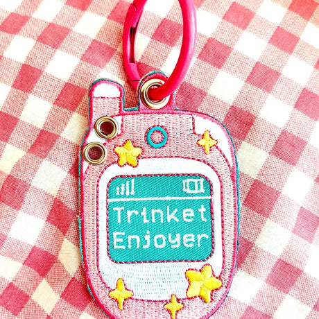These cute embroidered keychains attach with a colorful ring clasp and are perfect for attaching to your keys or bag to bring with you on all of your adventures! This design features extra grommets to hang more keychains and knick knacks!

Includes one keychain only.
Embroidered on both sides. The design is the same on both sides.
Materials: Cotton, Polyester, Brass