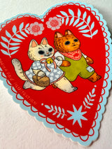 Two cats go for a walk on this folk art inspired sticker.

This vinyl matte sticker is weather and waterproof-stick it on a notebook, bike, or car- it's going to stick around! Heck, throw it on a water bottle and through the dishwasher. This sticker can go anywhere. Sticker measures 3.5" x 4.5" Printed in USA.
