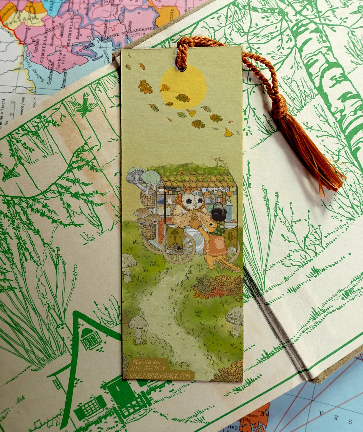 Acorn Market is open for business. Day or night, Owl will be attending its customers.

Bookmarks are double sided with different art of the market open in day and night on each side.

Printed on heavy cardstock and comes with a tassel, these bookmarks measure 2x6 inches.&nbsp;

Printed in USA