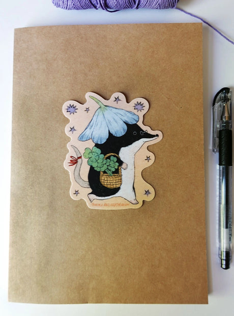 A shrew goes for a walk with some luck in their pocket! This vinyl matte sticker is weather and waterproof-stick it on a notebook, bike, or car- it's going to stick around! Heck, throw it on a water bottle and through the dishwasher. This sticker can go anywhere.

Sticker measures 3" x 4"

Printed in USA.