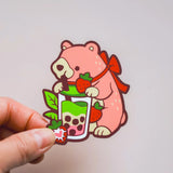 Cartoon bear holding a bubble tea with a hand on a light gray background
