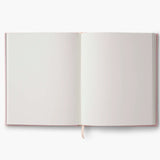 Our embroidered sketchbook is a large, hardcover journal with 108 unlined pages of thick paper perfect for sketching, drawing, and journaling. The cover is wrapped in cream book cloth and embroidered with an enchanted forest scene with metallic gold accents. An attached grosgrain ribbon bookmark will save your place