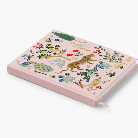 Our embroidered sketchbook is a large, hardcover journal with 108 unlined pages of thick paper perfect for sketching, drawing, and journaling. The cover is wrapped in cream book cloth and embroidered with an enchanted forest scene with metallic gold accents. An attached grosgrain ribbon bookmark will save your place