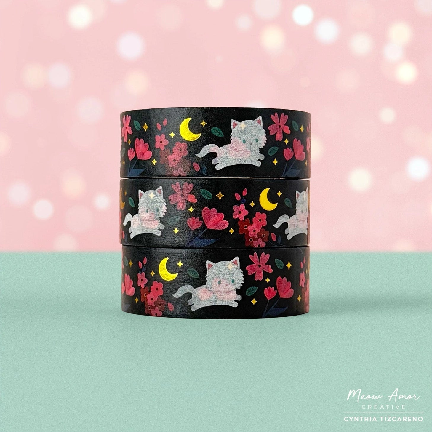 Brighten your crafts with the Floral Fluffy White Cat Gold Foil Washi Tape. Featuring a fluffy white cat surrounded by delicate pink florals set against a sleek black background, this tape is enhanced with shimmering gold foil details for a charming and elegant look. Perfect for adding a sweet, stylish touch to your planners, gifts, and creative projects.

Gold Foil Details&nbsp;
One 10-meter long roll of washi tape
15mm wide
32mm paper core