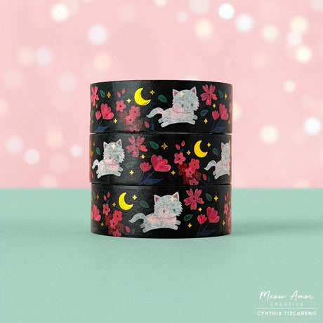Brighten your crafts with the Floral Fluffy White Cat Gold Foil Washi Tape. Featuring a fluffy white cat surrounded by delicate pink florals set against a sleek black background, this tape is enhanced with shimmering gold foil details for a charming and elegant look. Perfect for adding a sweet, stylish touch to your planners, gifts, and creative projects.

Gold Foil Details&nbsp;
One 10-meter long roll of washi tape
15mm wide
32mm paper core
