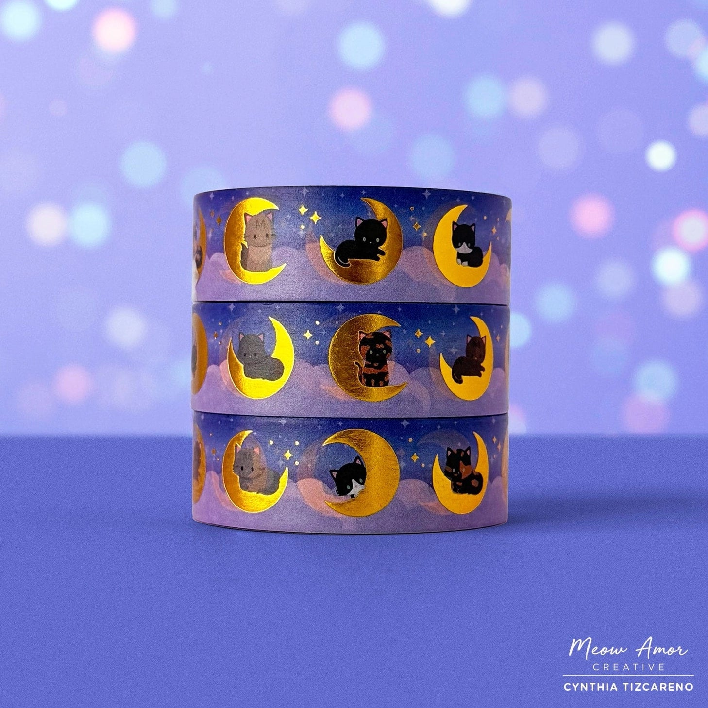 Add a magical glow to your projects with the Moon Cats Gold Foil Washi Tape. Featuring adorable cats surrounded by moon and star designs, this tape shines with elegant gold foil accents. Perfect for adding a cute, celestial touch to planners, gifts, and crafts.

Gold Foil Details&nbsp;
One 10-meter long roll of washi tape
15mm wide
32mm paper core