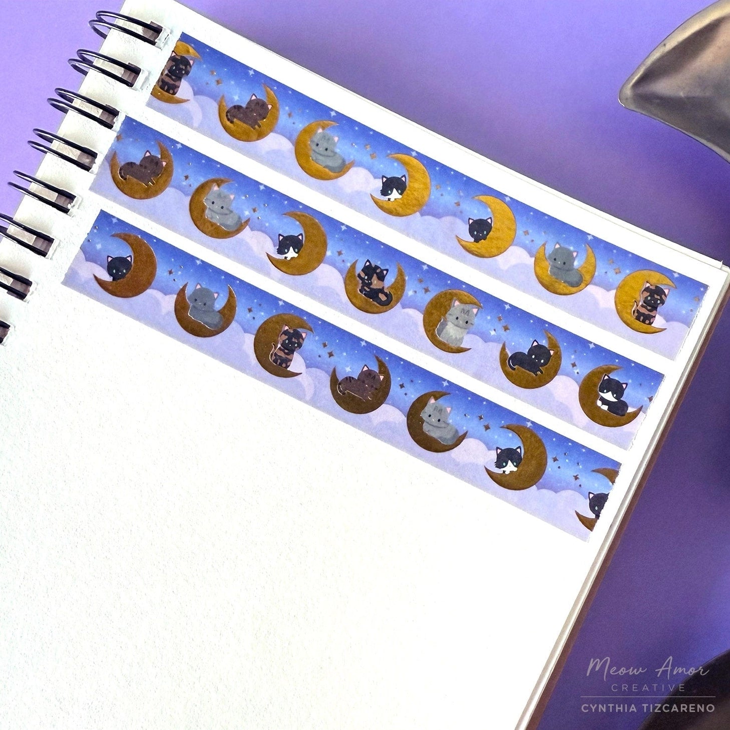 Add a magical glow to your projects with the Moon Cats Gold Foil Washi Tape. Featuring adorable cats surrounded by moon and star designs, this tape shines with elegant gold foil accents. Perfect for adding a cute, celestial touch to planners, gifts, and crafts.

Gold Foil Details&nbsp;
One 10-meter long roll of washi tape
15mm wide
32mm paper core