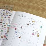 Calendar with animal stickers on a wooden surface
