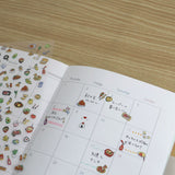 Calendar with illustrated food items on a wooden surface