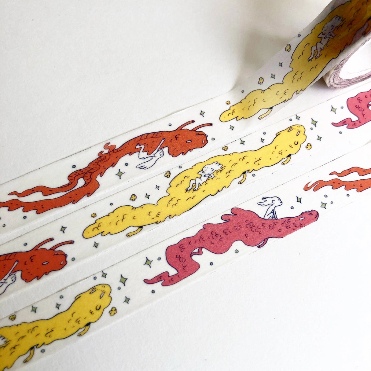 This Dragon washi tape features three soft, fluffy dragons that the dragon rider girl has befriended.

This roll is 15mm wide x 10m of paper tape. Washi tape is super durable and flexible. It tears easily and can be safely applied to a variety of surfaces; it doesn’t leave a sticky residue behind, making it especially ideal for stationery and hanging prints temporarily.