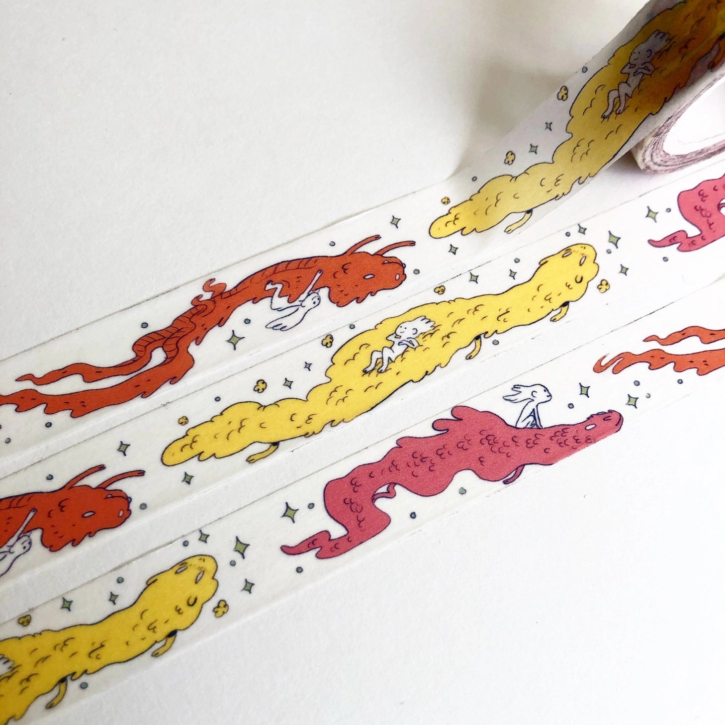 This Dragon washi tape features three soft, fluffy dragons that the dragon rider girl has befriended.

This roll is 15mm wide x 10m of paper tape. Washi tape is super durable and flexible. It tears easily and can be safely applied to a variety of surfaces; it doesn’t leave a sticky residue behind, making it especially ideal for stationery and hanging prints temporarily.