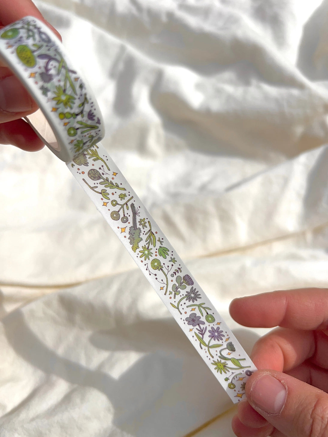This washi tape features fluid green and purple flowers dancing loosely around to create an energetic, yet soft tape. 

This roll is 15mm wide x 10m of paper tape. Washi tape is super durable and flexible. It tears easily and can be safely applied to a variety of surfaces; it doesn’t leave a sticky residue behind, making it especially ideal for stationery and hanging prints temporarily.