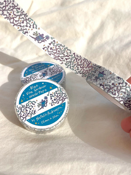 This washi tape features three little blue gardeners who work to keep the vines at bay.

This roll is 15mm wide x 10m of paper tape. Washi tape is super durable and flexible. It tears easily and can be safely applied to a variety of surfaces; it doesn’t leave a sticky residue behind, making it especially ideal for stationery and hanging prints temporarily.