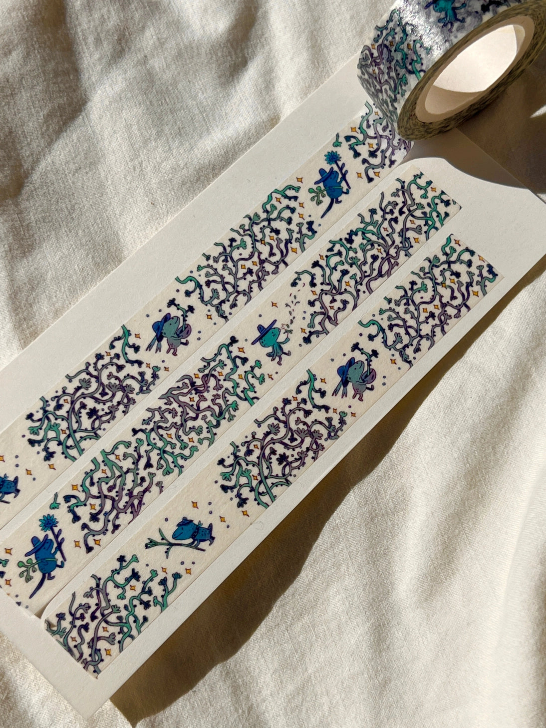 This washi tape features three little blue gardeners who work to keep the vines at bay.

This roll is 15mm wide x 10m of paper tape. Washi tape is super durable and flexible. It tears easily and can be safely applied to a variety of surfaces; it doesn’t leave a sticky residue behind, making it especially ideal for stationery and hanging prints temporarily.