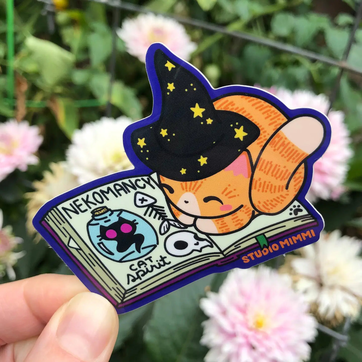 STUDIO Mimi - Neko'mancy Spellbook with Crookshanks Vinyl Sticker

This sticker is designed from one of my Spellbook Cat sculptures with little extra details added; a starry hat, loose page and bookmark.

Sticker Size: 2.9” x 2.8”
Printed on a white premium adhesive film with a glossy weather resistant laminate for a 2-4 year minimum outdoor life.
Printed on a PVC-free film that’s environmentally friendly.