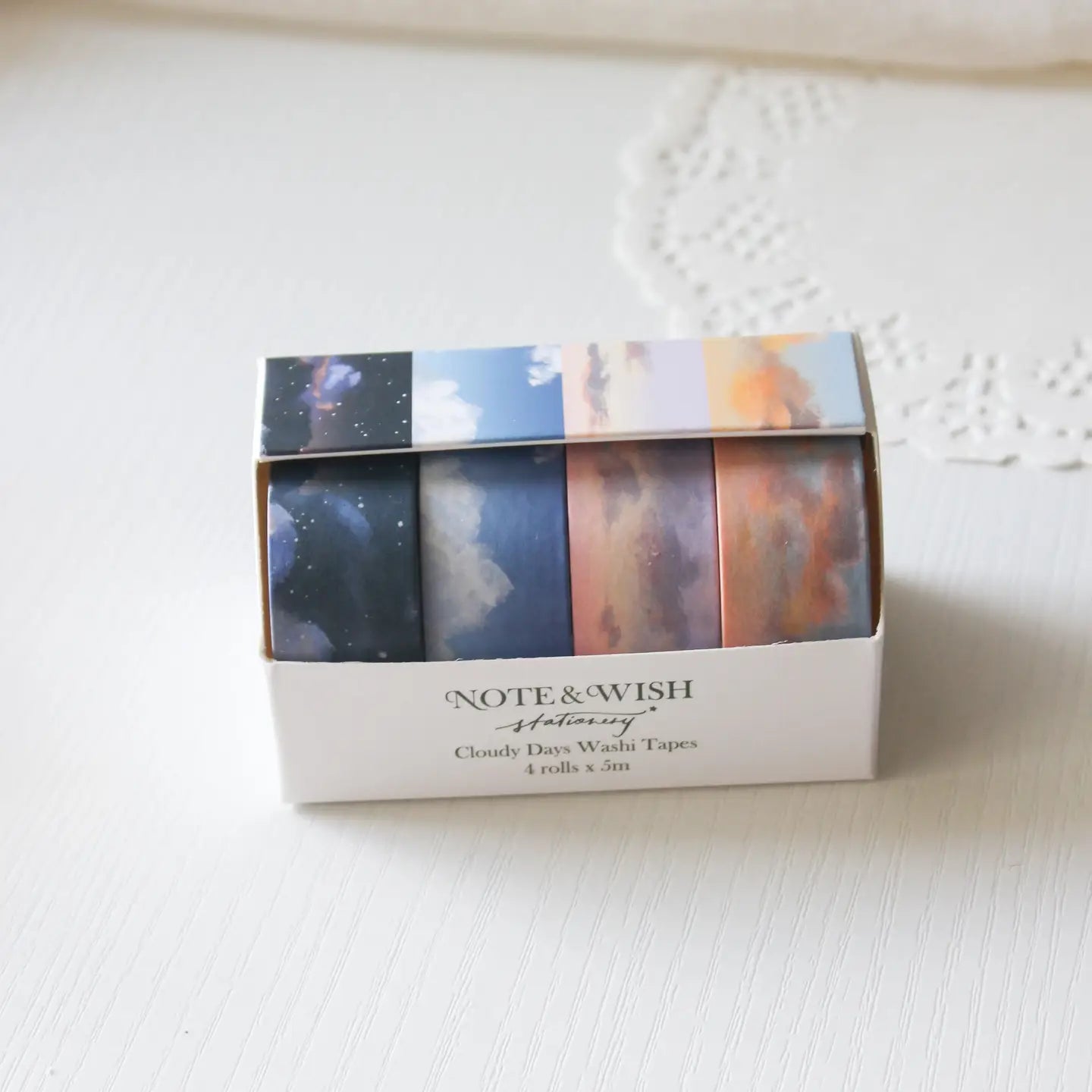 This washi tape box set is designed for journalers, sky gazers, and stationery lovers who find beauty in the ever-changing colours of the sky. Featuring four digitally drawn skyscape designs by Rebecca, each roll captures a different season, from soft spring sunrises to moody winter twilights, all packaged in a beautiful presentation box.

The four designs included:

&nbsp;* Cloudy Days Spring — soft purple and peach sunrise tones&nbsp;
&nbsp;* Cloudy Days Summer — sky blue with drifting white clouds&nbsp;

