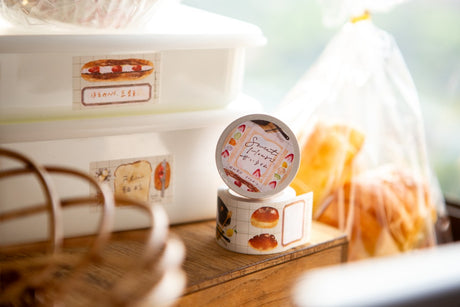 OURS Studio Sweet Hours Sticker Memo Roll Small round container with a lid on a wooden surface, with a blurred background