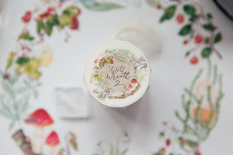 OURS Studio Wild Wreath 2 Washi Tape Decorative bottle cap with floral design and text on a floral-patterned background