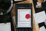 OURS Studio Wooden Frame Letterpress Label Book Decorative paper with a red wax seal on a wooden surface with stationery items.