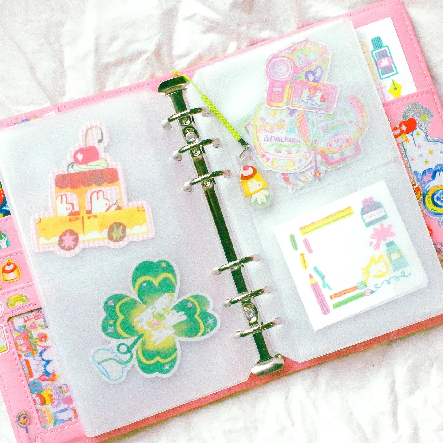 This is a A6 six ring binder that measures 14 cm x 19 cm when closed! It includes interior pockets for extra storage and a hole on the spine for charms.

This binder is great for storing stickers, sticker packs, note cards, photo cards, pet tape loops, ephemera and small sticker sheets. They can also be filled with paper and used as a notebook or journal.