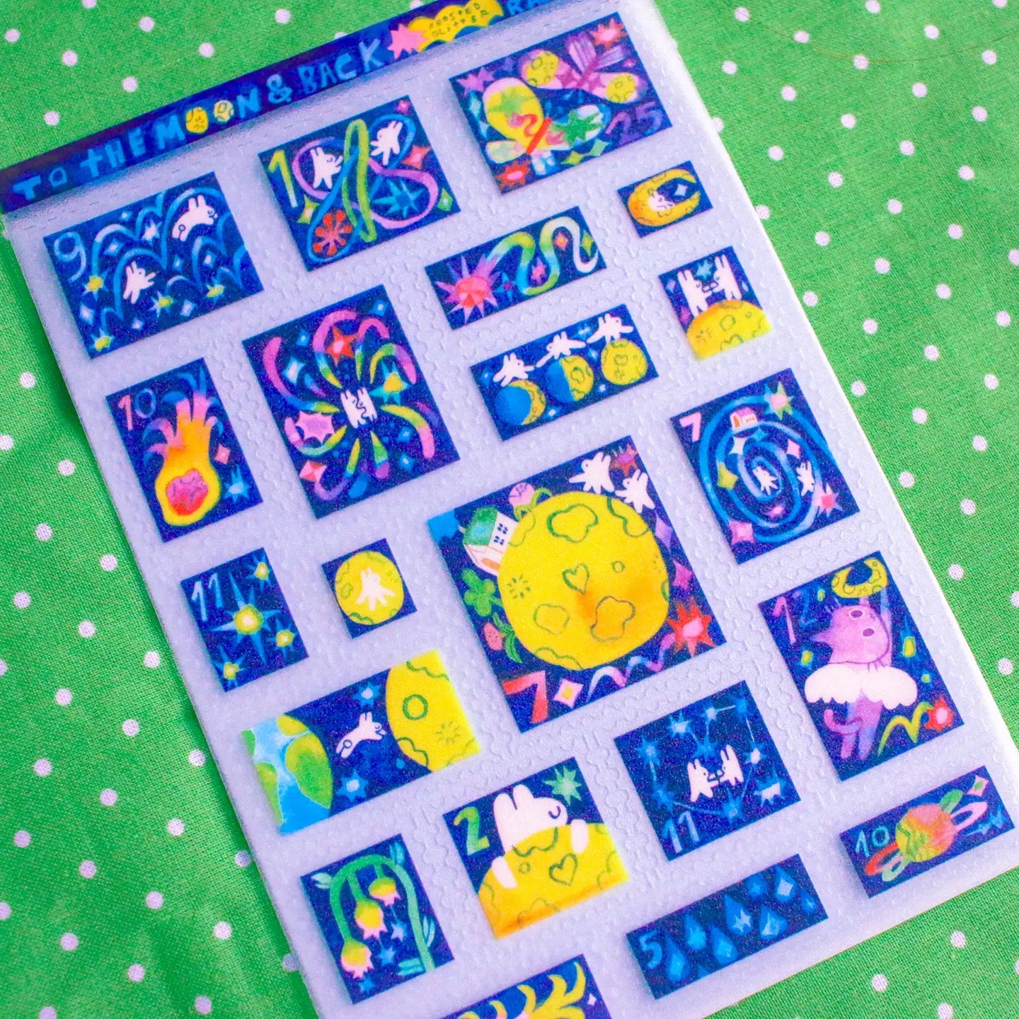 'To the Moon &amp; Back' Frosted Glitter Transparent A6 Sticker Sheet. Stickers are stamp shaped and have a clear blue background.

Not waterproof.
Do not place in areas of high wear (laptops, phone cases, water bottles, etc).
Sticker sheets come packaged in a plastic sleeve.