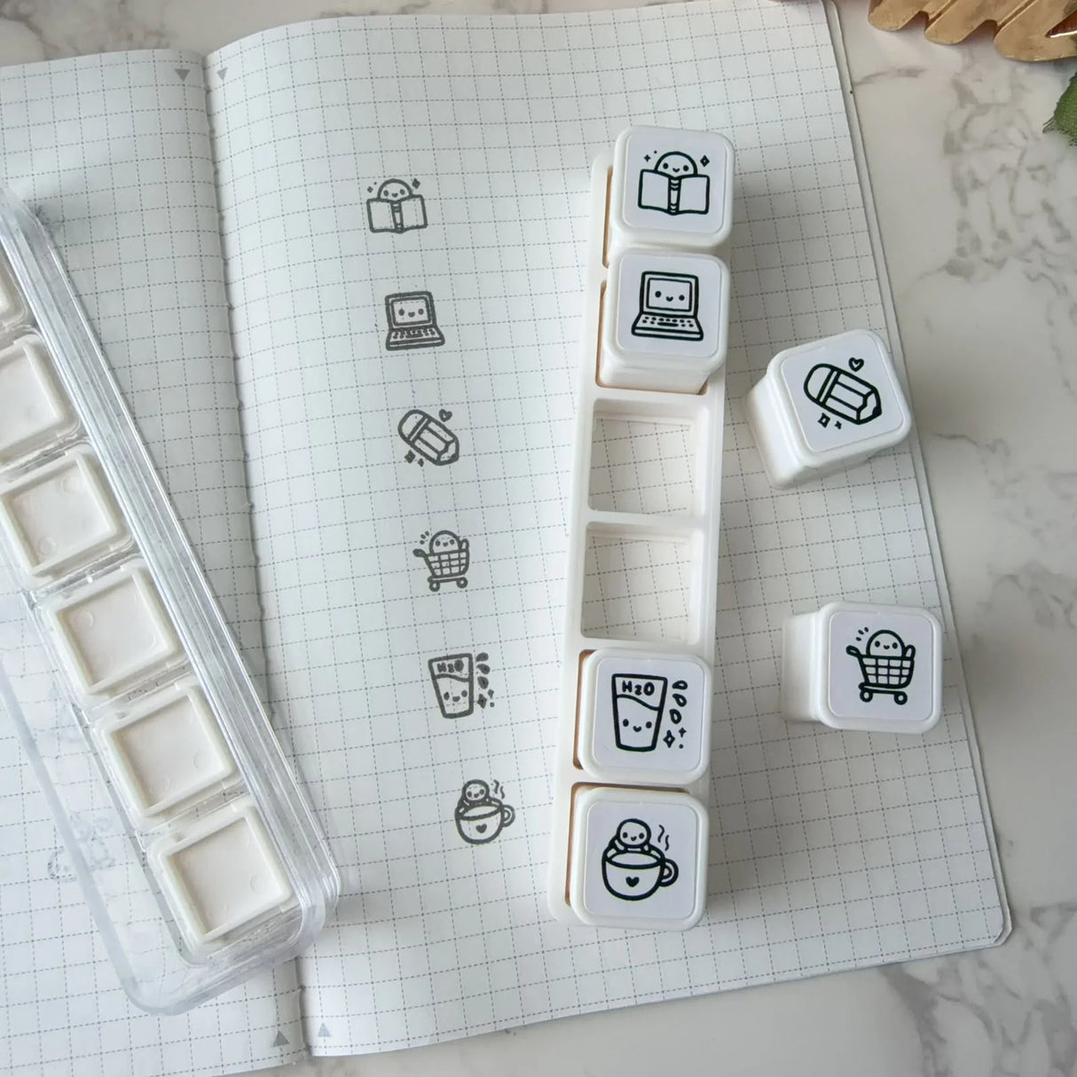 6-in-1 removable stamps for Daily Essentials.

Can be used right in the bracket or taken out for more precise stamping. The stamps are self-inking and come in a transparent case!

***IMPORTANT:&nbsp;Stamps come very well inked. Make sure you use scrap paper to stamp off excess ink prior to using in your notebooks

STAMP SET SIZE:&nbsp;10.75cm&nbsp;(L) x 2.5cm (W) x 2.75cm (H)
INDIVIDUAL STAMP SIZE:&nbsp;1.5cm x 1.5cm
INK COLOUR:&nbsp;Black (refillable)