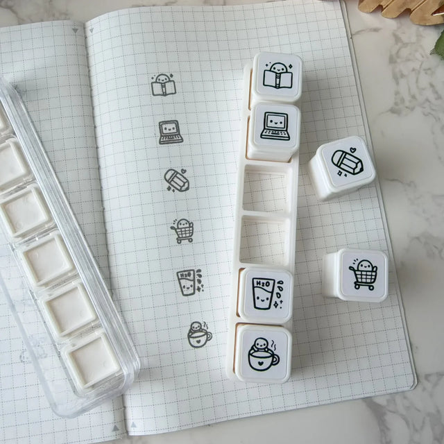 6-in-1 removable stamps for Daily Essentials.

Can be used right in the bracket or taken out for more precise stamping. The stamps are self-inking and come in a transparent case!

***IMPORTANT:&nbsp;Stamps come very well inked. Make sure you use scrap paper to stamp off excess ink prior to using in your notebooks

STAMP SET SIZE:&nbsp;10.75cm&nbsp;(L) x 2.5cm (W) x 2.75cm (H)
INDIVIDUAL STAMP SIZE:&nbsp;1.5cm x 1.5cm
INK COLOUR:&nbsp;Black (refillable)