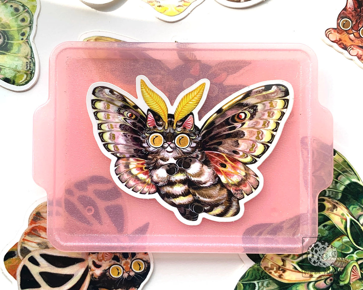 “Pine” is a sticker from the Moth Cat series and is inspired by the Pandora Pinemoth, a native species to Oregon. 

Moth Cats are a curious and captivating species. The colorful and detailed illustrations are original paintings on birch wood panels.

+ size: 1.7 x 2.3"
+ permanent adhesive glossy vinyl sticker with solid peel backing
+ scratch and weather resistant material, PVC free
+ packaged and shipped flat

All work and photos ©PAPER PUFFIN Art by K.CARLSON
