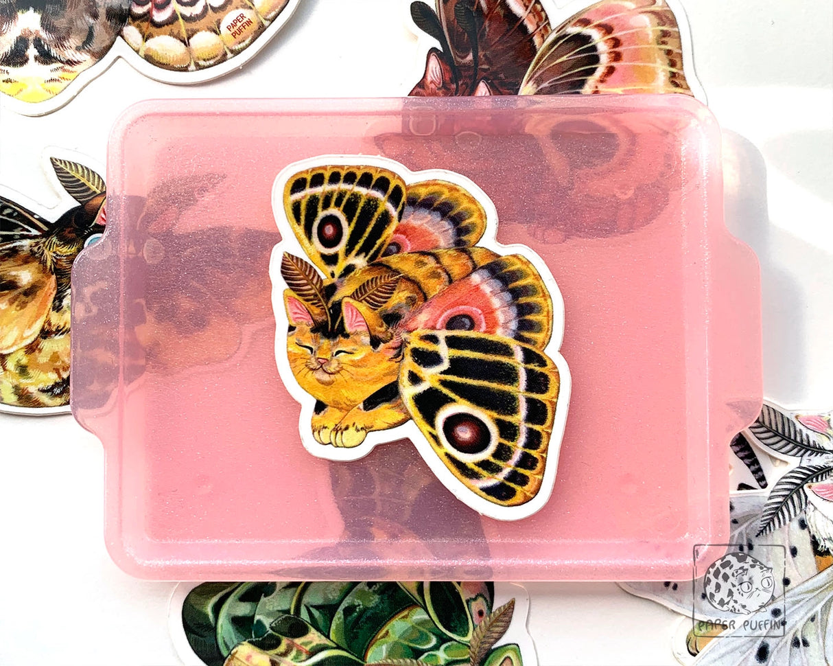 “Vivid Joy” is a colorful and patterned moth from the Moth Cat series.

Moth Cats are a curious and captivating species. The colorful and detailed illustrations are original paintings on birch wood panels.

+ size: 1.7 x 2.3"
+ permanent adhesive glossy vinyl sticker with solid peel backing
+ scratch and weather resistant material, PVC free
+ packaged and shipped flat

All work and photos ©PAPER PUFFIN Art by K.CARLSON